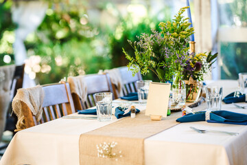 Outdoor wedding table decoration with fresh flowers and blank table cards. Special event table set up. Boho wedding decoration.