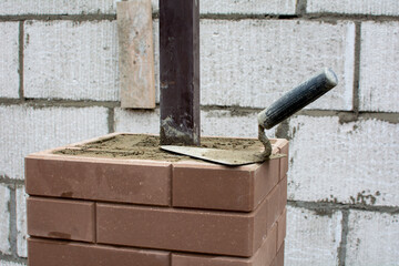Construction of a brick fence using clinker bricks and cement with a columnar Foundation....