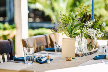 Outdoor wedding table decoration with fresh flowers and blank table cards. Special event table set up. Boho wedding decoration.