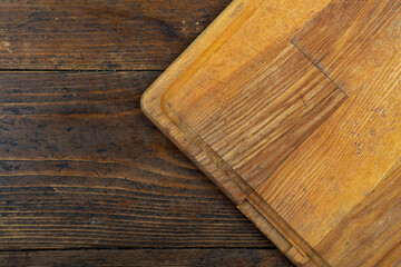 Empty cutting board on a wooden table. Space for text.
