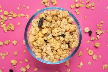 Cereal. Breakfast with muesli and raisins on a pink background. Space for text. Top view.