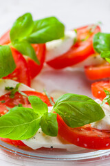 caprese salad with ripe tomatoes and mozzarella cheese with fresh basil leaves. Italian food