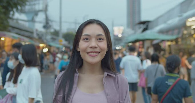 Slow motion portrait young women Asian confidence in smiling with blurred of people walking  background