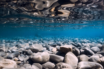 Underwater sea with stones, reflection and water.