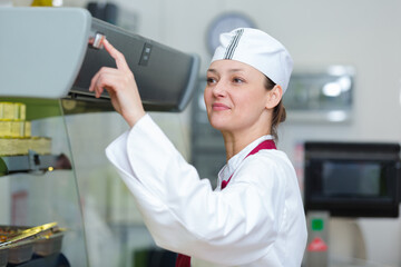 woman pressing switch on food cabinet