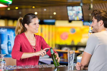 pretty barmaid talking with handsome customer in a bar