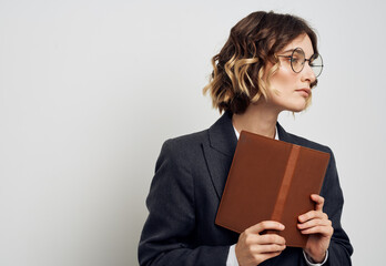 Woman in classic suit with open book glasses on face cropped view on light background