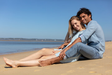 attractive couple in white summer clothing on the beach