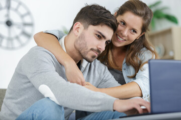 happy couple using a laptop at home