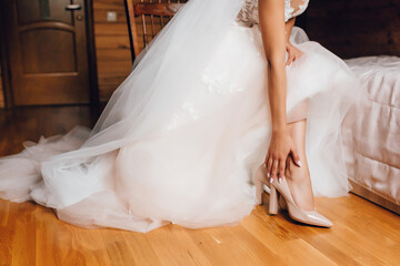 Fototapeta na wymiar Bride in a white wedding dress puts tuli on her legs