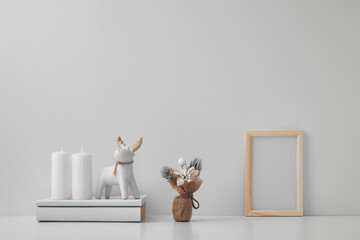 Porcelain figurine of a deer and New Year's decor and candles. Copy space, mock up.