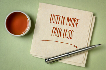 listen more, talk less - inspirational handwriting on a napkin with a cup of tea, communication and personal development concept