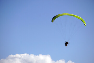Paraglider over the sunny clouds