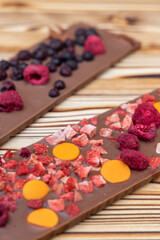 different kinds of chocolate with dried fruits on a wooden board
