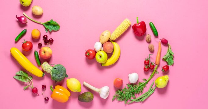 Fresh organic vegetables and fruits move into a pile on a pink background, stop motion. Vegetables animation. 
Flat lay 4 video with vegetables.