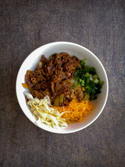 Japanese food. beef teriyaki in white bowl with vegetable, slice of carrot and cabbage