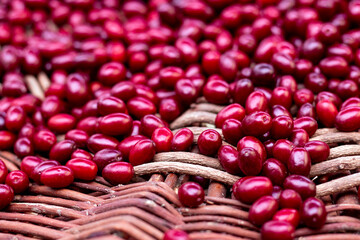 Fresh dogwood red berries on wooden basket. Fresh cornel berries. Selective focus.