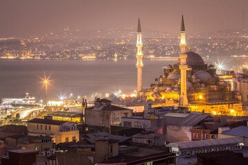 Cityscape of night Istambul and the Yeni Cami (New Mosque), situated on the Golden Horn, at the southern end of the Galata Bridge. It's one of the famous architectural landmarks of Istanbul. Turkey.