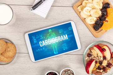 CARDIOGRAM concept in tablet with fruits, top view