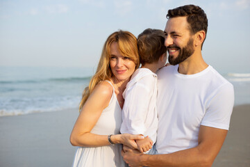 Obraz premium Portrait of a happy young family with a child on a tropical beach. India