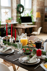Festive table served with homemade orange juice, berry drink and vegetable salad