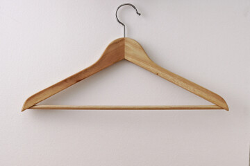 Wooden hanger on a white background. Organization of storage in the wardrobe. Copy space