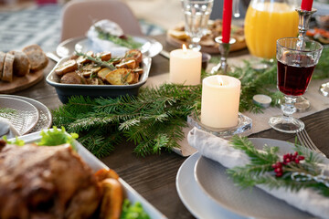 Fototapeta na wymiar Part of festive table served with jug of orange juice, roasted potatoes, turkey