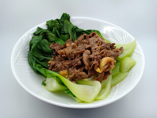 Sauté pokcoy vegetables with thin slices of beef cooked with garlic. Very popular Chinese food because it tastes so good and healthy. isolated on white background