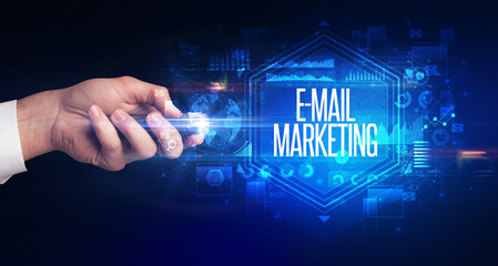 hand holding wireless peripheral with E-MAIL MARKETING inscription, cyber security concept