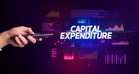 hand holding wireless peripheral with CAPITAL EXPENDITURE inscription, cyber business concept