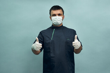 The doctor holds out his hand with a raised thumb up. Approval, encouragement. Personal protective equipment