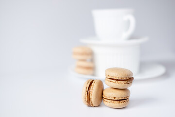 macarons in a coffee cup. caramel macaroons. Light flatley with dessert. Macaroni on white background. Cozy winter photography