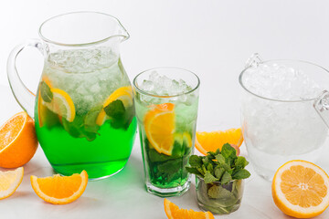 Side view on green lemonade in a jug and glass