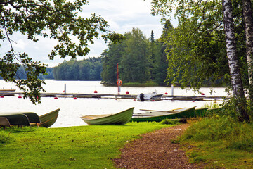 Pieceful view of the river flowing among forests, and boats on its bank. There are no people. Finland.