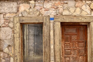 old stone building with wooden door and window frame