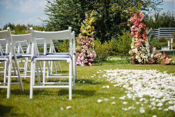 Open air wedding ceremony with arch and chairs