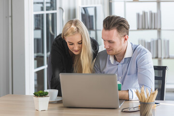 Young business man and woman working from home-office with morning sunshine. They are communicating in social network and searching information online.