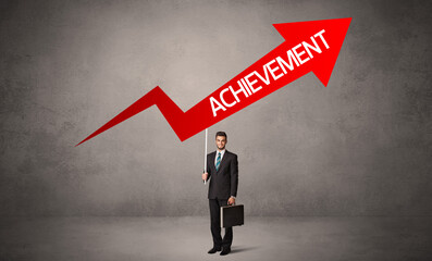 Obraz premium Young business person in casual holding road sign with ACHIEVEMENT inscription, business direction concept