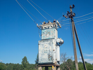 Old and rusty transformer station in summer on a clear day against the blue sky