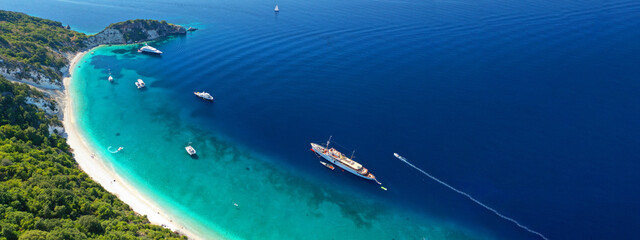 Aerial drone top down ultra wide photo of luxury yacht anchored in tropical exotic island turquoise...