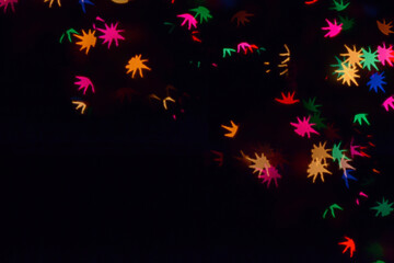 Bokeh lights background. Stars bokeh defocused background. Holiday background. Garland. Defocused blinks. New Year. Bokeh retro style photo.