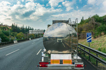 Steel tank truck driving on the highway, rear view.