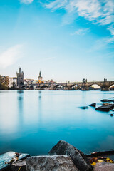 Naklejka premium The Charles Bridge at sunset on long exposure with vltava river in foreground, Prague, Czech Republic,