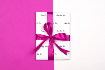 X-mas gift wrapped in paper with Christmas prints and tied with black ribbon. Christmas present box...