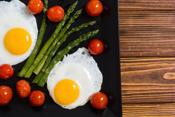 Healthy breakfast with eggs , asparagus and tomatoes