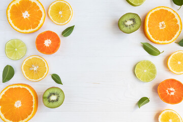 Lemons, lime, orange and grapefruit tangerines and kiwi cut into circles on a white background with space for text. Poster, banner, article.