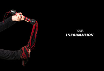 Leather whip in woman hand. Woman's hand is holding bdsm lash on isolated on black background. Accessories for adult sexual games. Toys for BDSM, flogging, sexual fetish and spanking devices