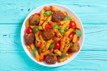 Italian penne pasta with meatballs and tomatoes