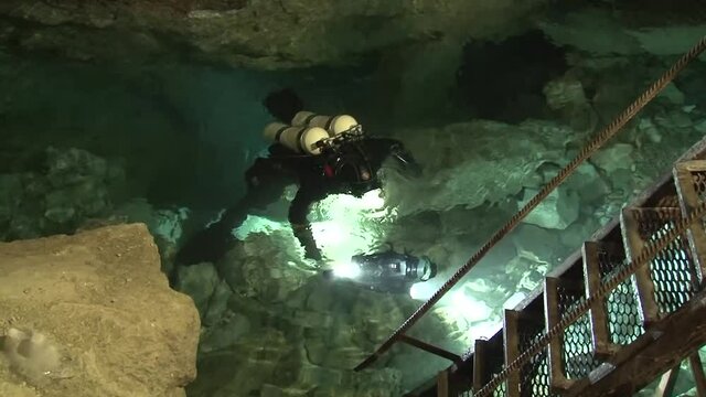 In a small, shallow underground lake located at the very bottom of an airy karst cavity, speleodivers are preparing for a long dive into the Orda underwater cave.