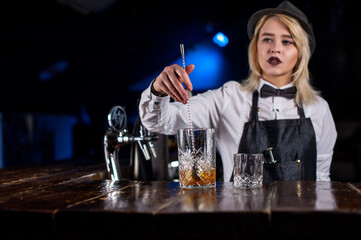 Girl bartender mixes a cocktail on the public house